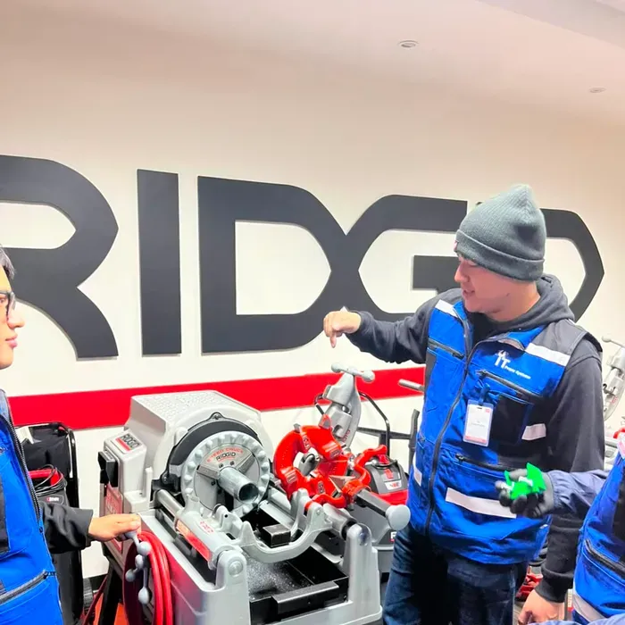 Técnico de iT Power Systems mostrando el uso de una roscadora durante una capacitación