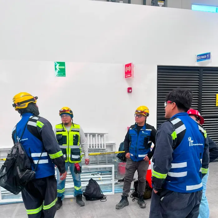 Cuadrilla de iT Power Systems preparando una intervención junto a tableros eléctricos en planta