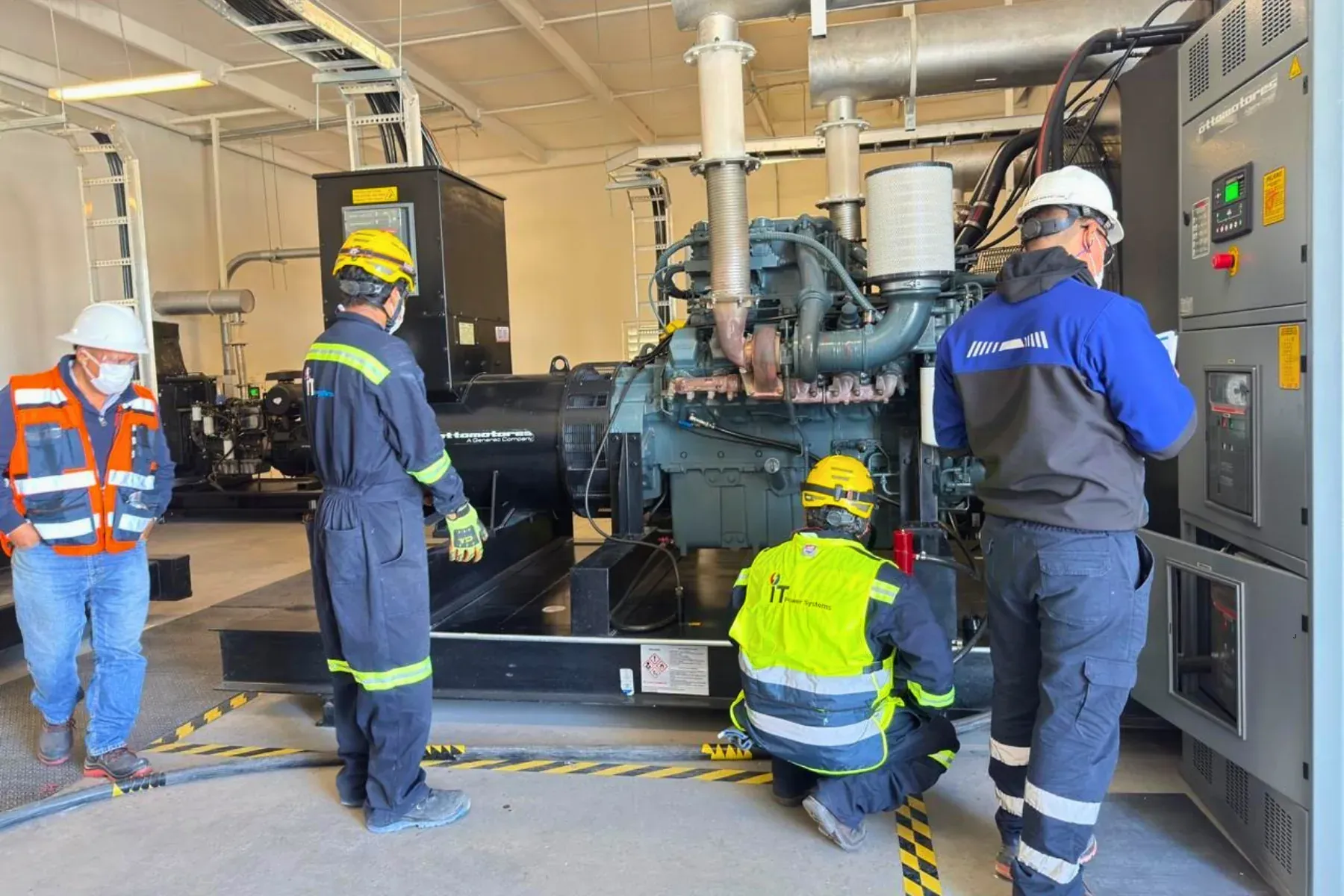 Cuadrilla de iT Power Systems inspeccionando una planta de emergencia diésel (motogenerador Ottomotores) en su cuarto de máquinas, junto al tablero de control